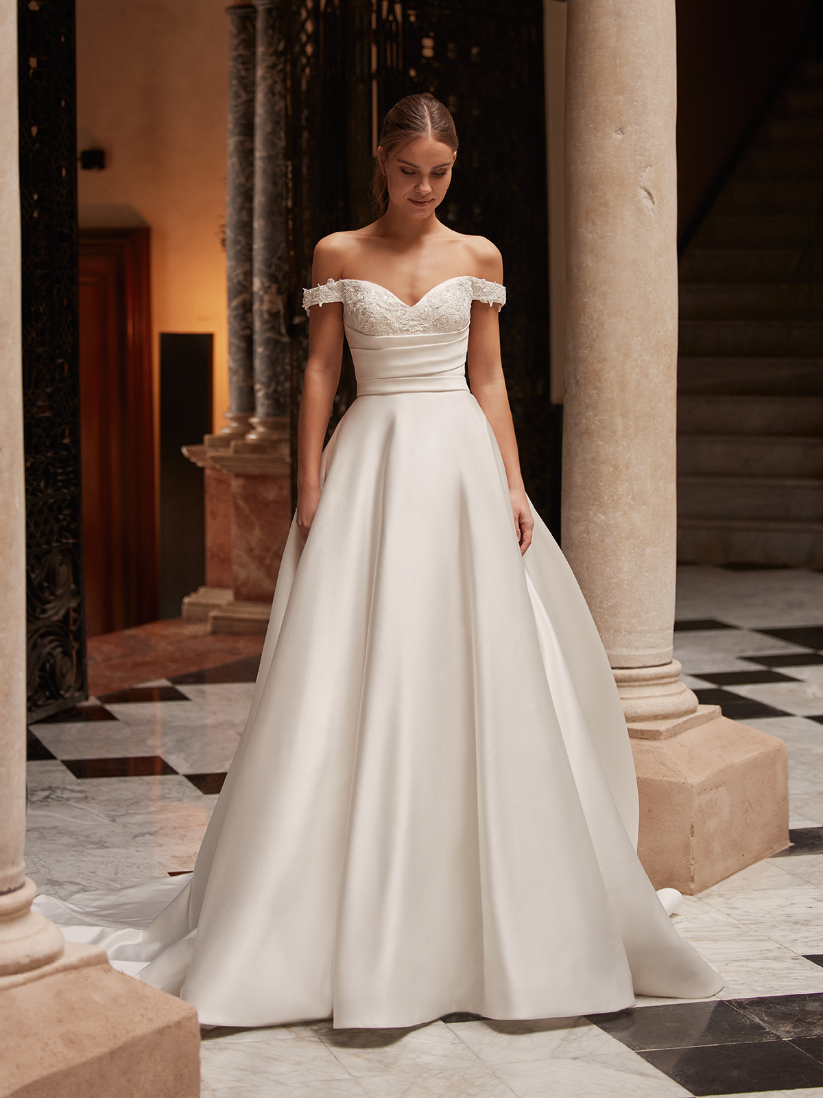 Woman wearing a classic stain ball gown wedding dress walking through a formal venue