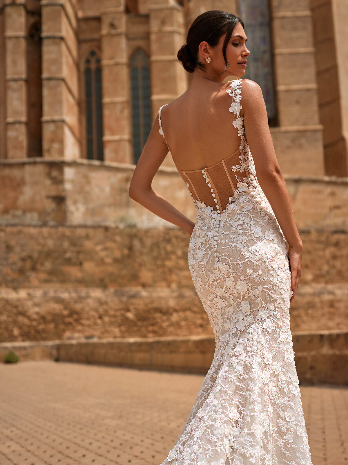 Woman shows 3D floral laces laying on the back of her wedding dress.