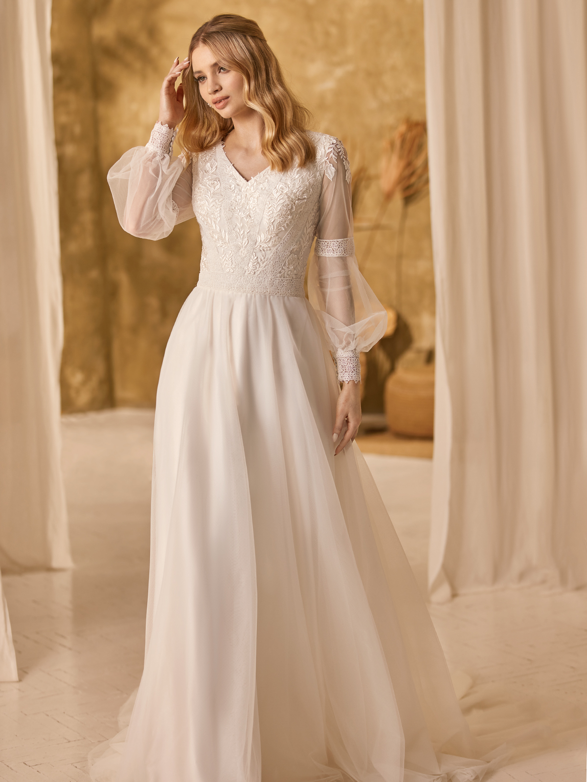 Bride wearing a minimalist wedding gown with flowy poet sleeves