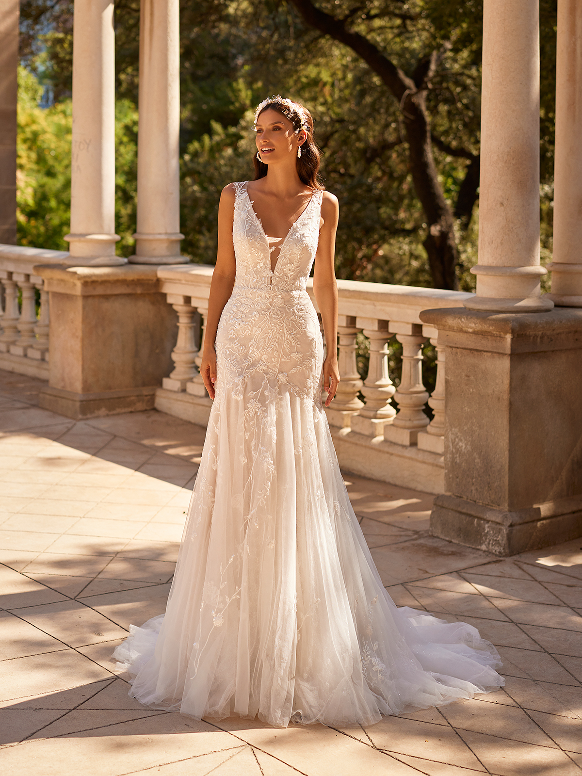 Bride standing outside in a lace mermaid wedding dress with a deep v-neckline