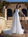 Elegant bride in Moonlight Couture H1586 a scoop neckline pearl beaded A-line wedding dress with thin sash, standing gracefully on steps.
