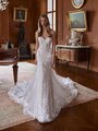 A bride stands in an opulent, vintage-style room wearing an elegant, strapless wedding gown with a fitted bodice and a sweetheart neckline. The dress features intricate lace detailing and floral appliqués, cascading down the gown A bride stands in an opulent, vintage-style room wearing an elegant, strapless wedding gown with a fitted bodice and a sweetheart neckline. The dress features intricate lace detailing and floral appliqués, cascading down the gown