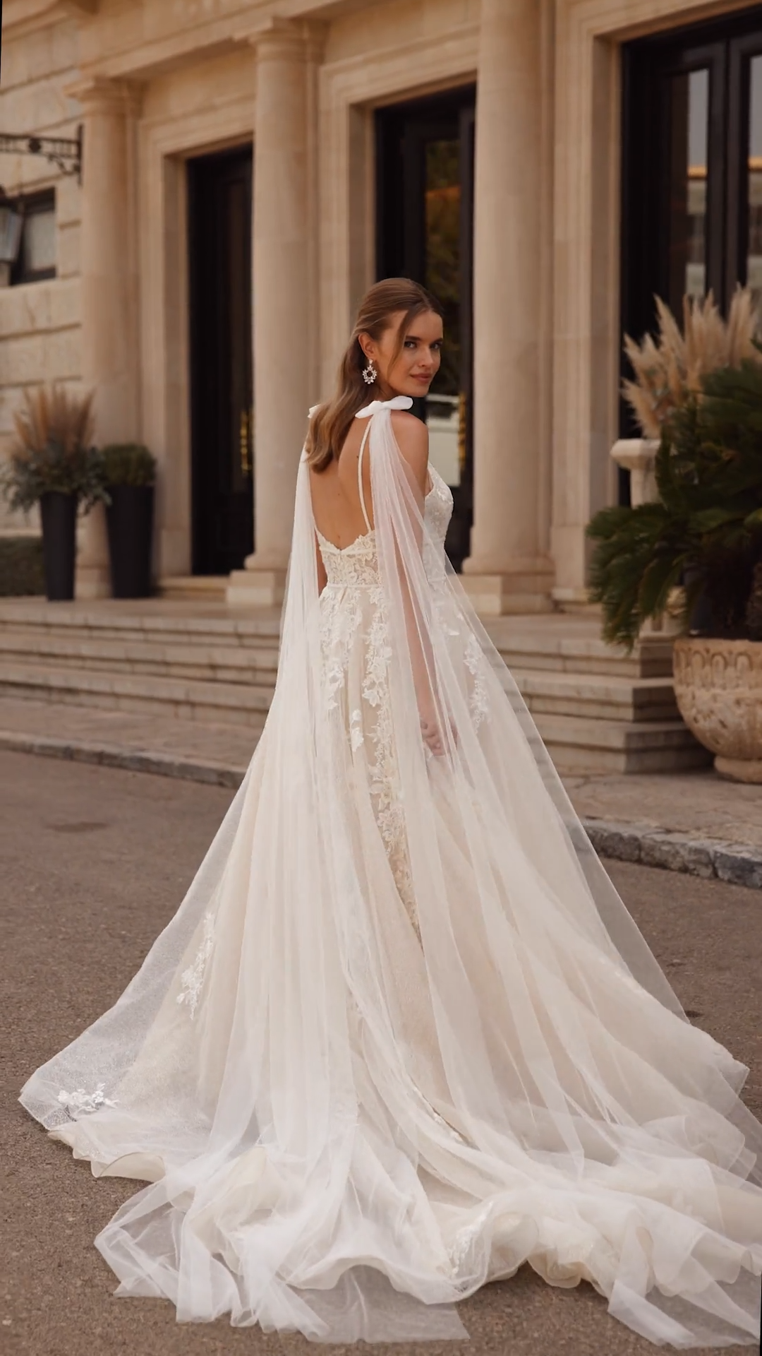 Bride Walking In A Full A-line Sparkly Lace Wedding Dress With Detachable Bow Tails On Shoulders