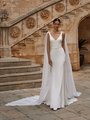 Bride walking in fitted mermaid crepe wedding dress with pearls, a deep v-neckline, and chiffon shoulder wings
